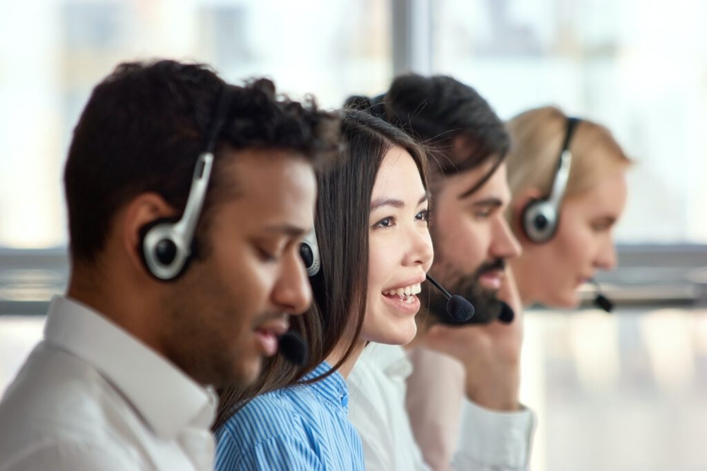 Four support phone operators at workplace.